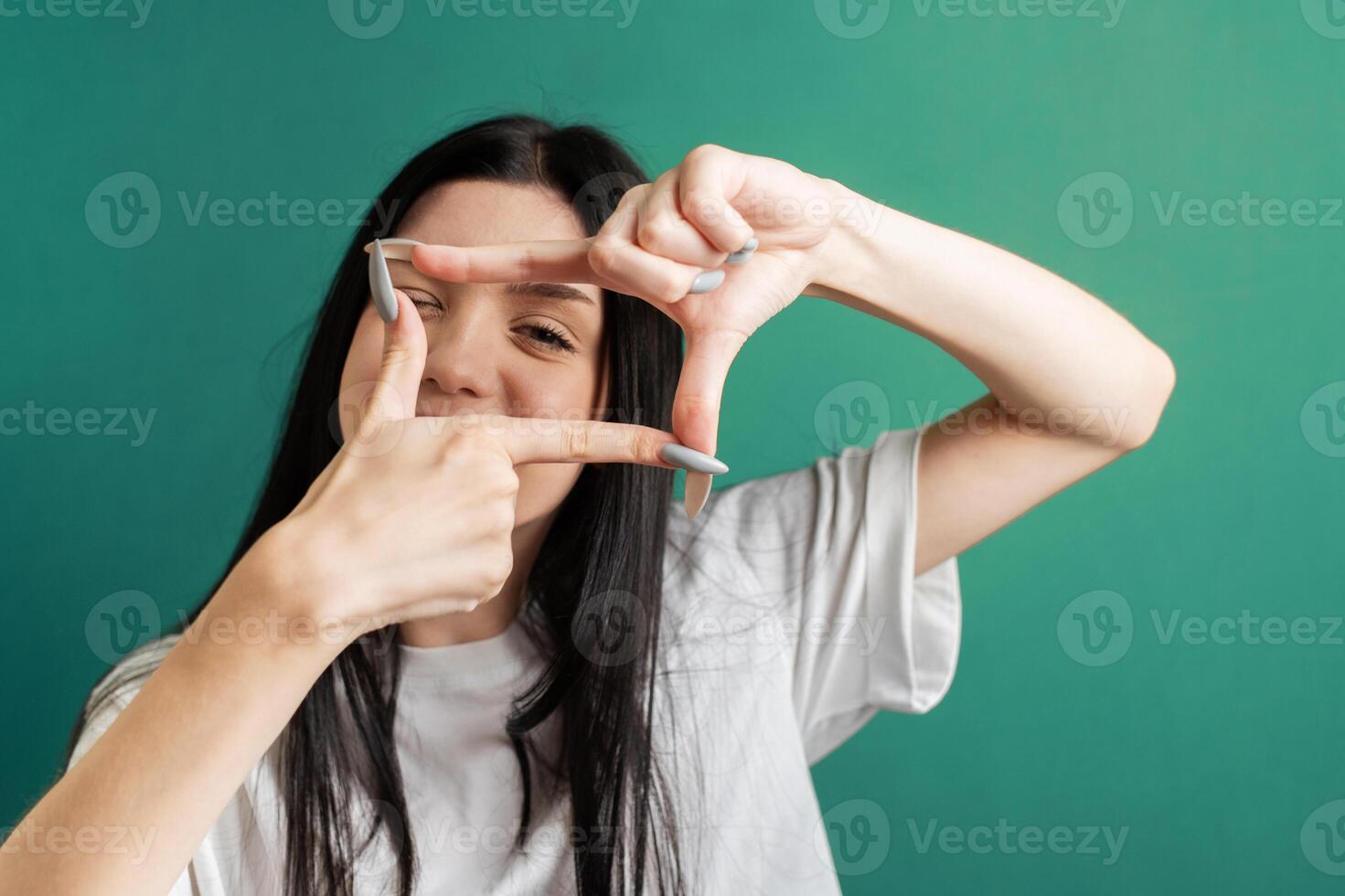 Young girl shows the frame with her hands photo