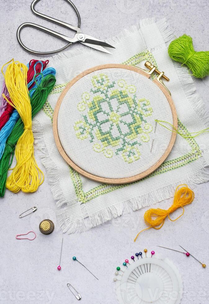 Embroidery with colored threads and various sewing accessories photo