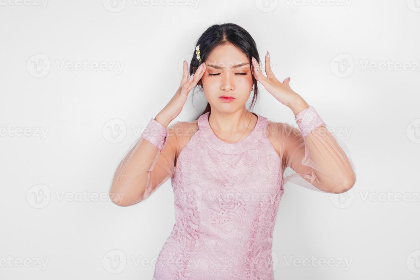 A sad Asian woman wearing a pink dress looks stressed and depressed, isolated white background. photo