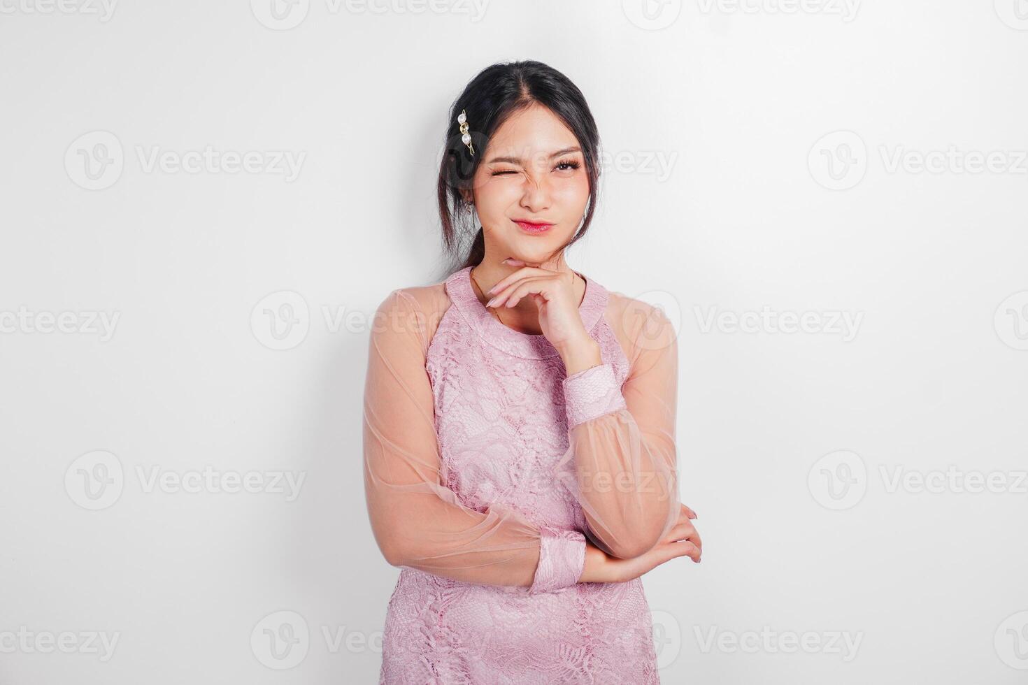 An attractive Asian woman wearing pink dress is smiling to the camera, isolated by white background. photo