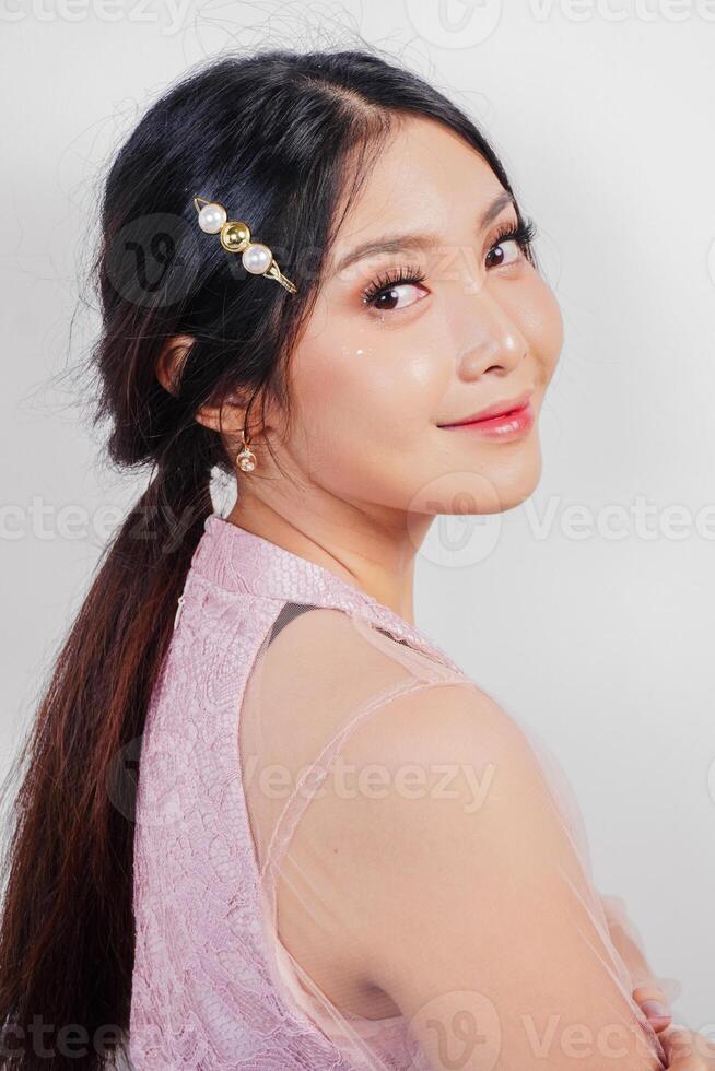 retrato de un joven hermosa asiático mujer vistiendo un rosado vestido, belleza disparar concepto foto