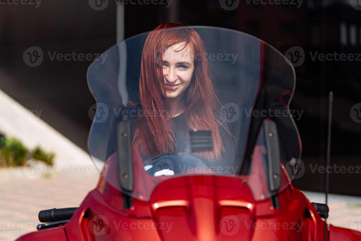 Red Motorcycle with Woman on Windshield. A red motorcycle with a picture of a woman on the windshield photo