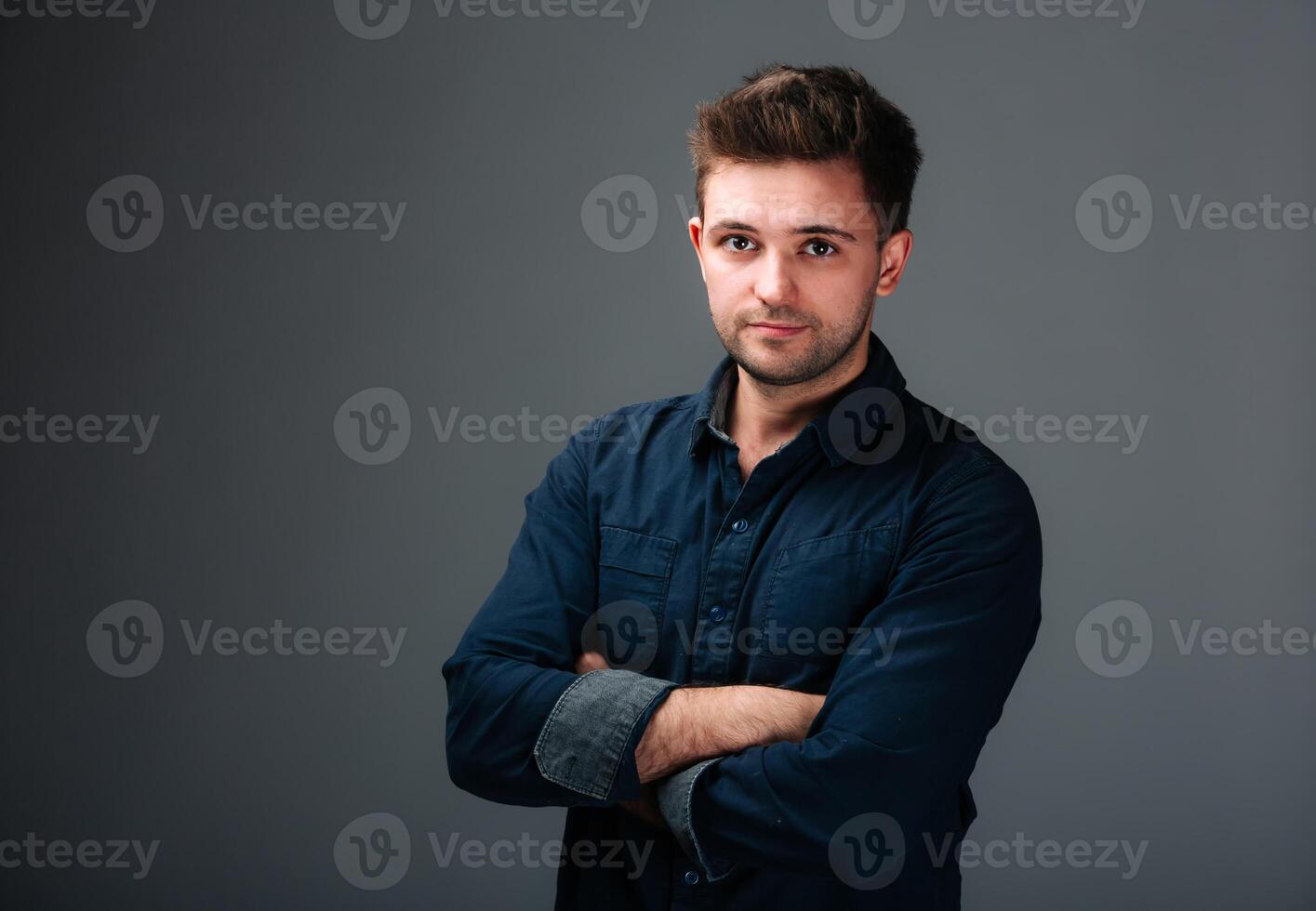 A Confident Man Striking a Pose. A man with his arms crossed posing for a picture photo