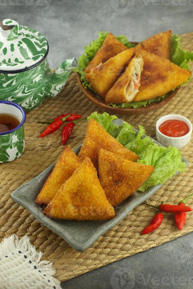 indonesio aperitivos, risoles triangulos saburral con migas de pan lleno con vegetales y servido calentar foto