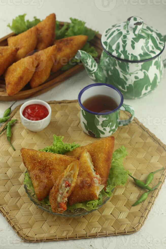 indonesio aperitivos, risoles triangulos saburral con migas de pan lleno con vegetales y servido calentar foto