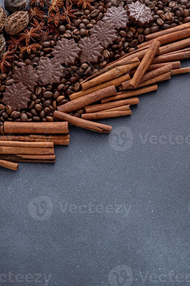 Food background. Coffee beans, cinnamon sticks, anise stars and chocolate candies. photo
