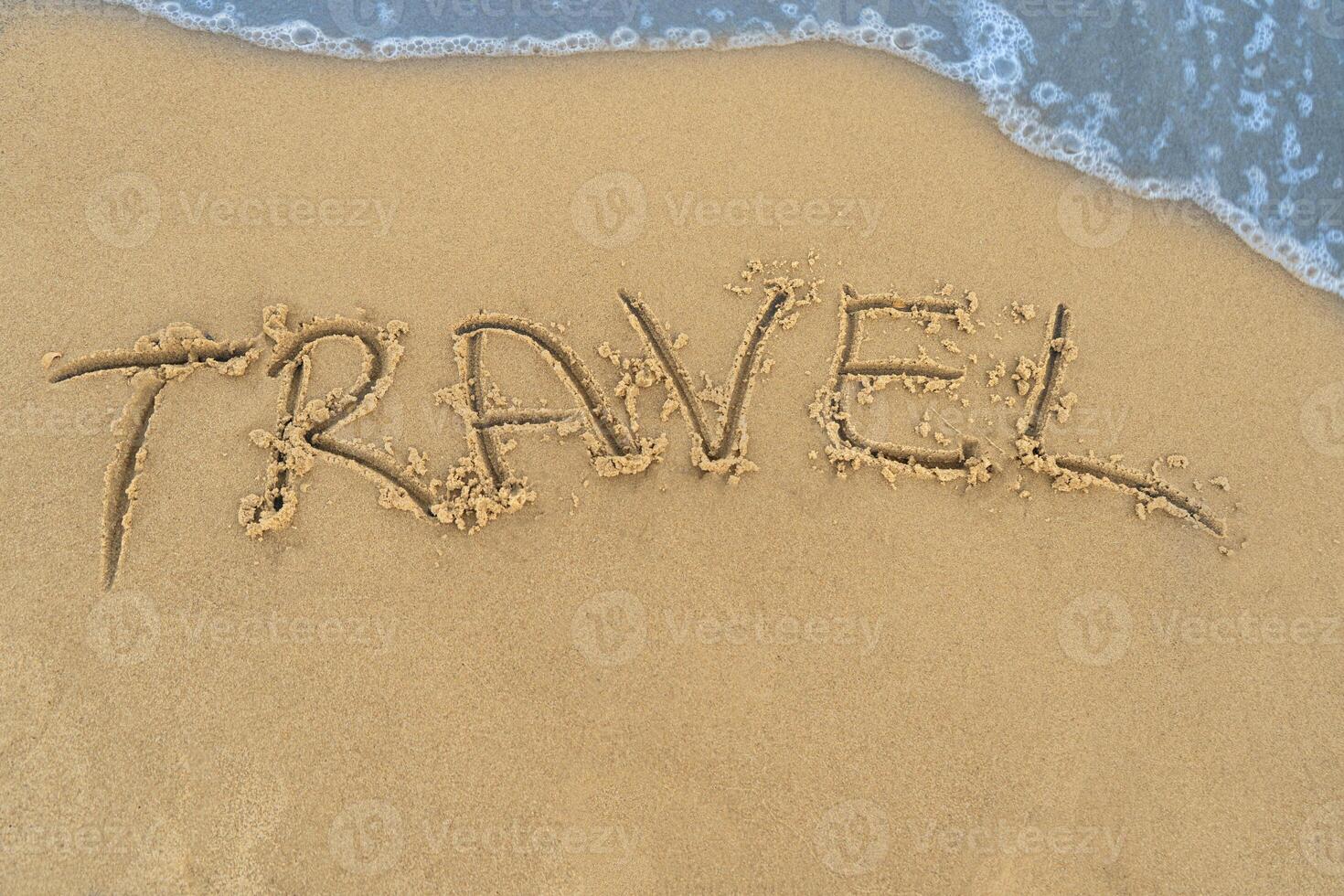 Travel concept - inscription in the sand. Sandy coast of the sea. Motivation. Ocean wave. The word travel is written on the sea beach. Vacations on the shore photo