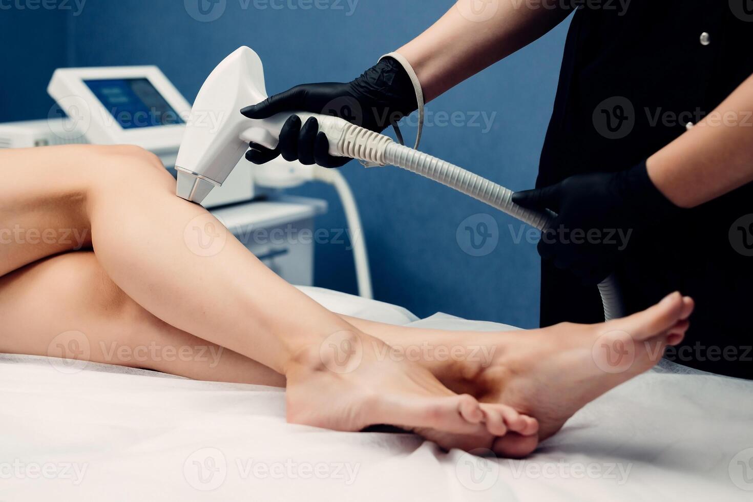 Close up of woman legs during procedure of laser hair removal in modern cosmetology clinic. Concept of women beauty, cosmetology, epilation photo