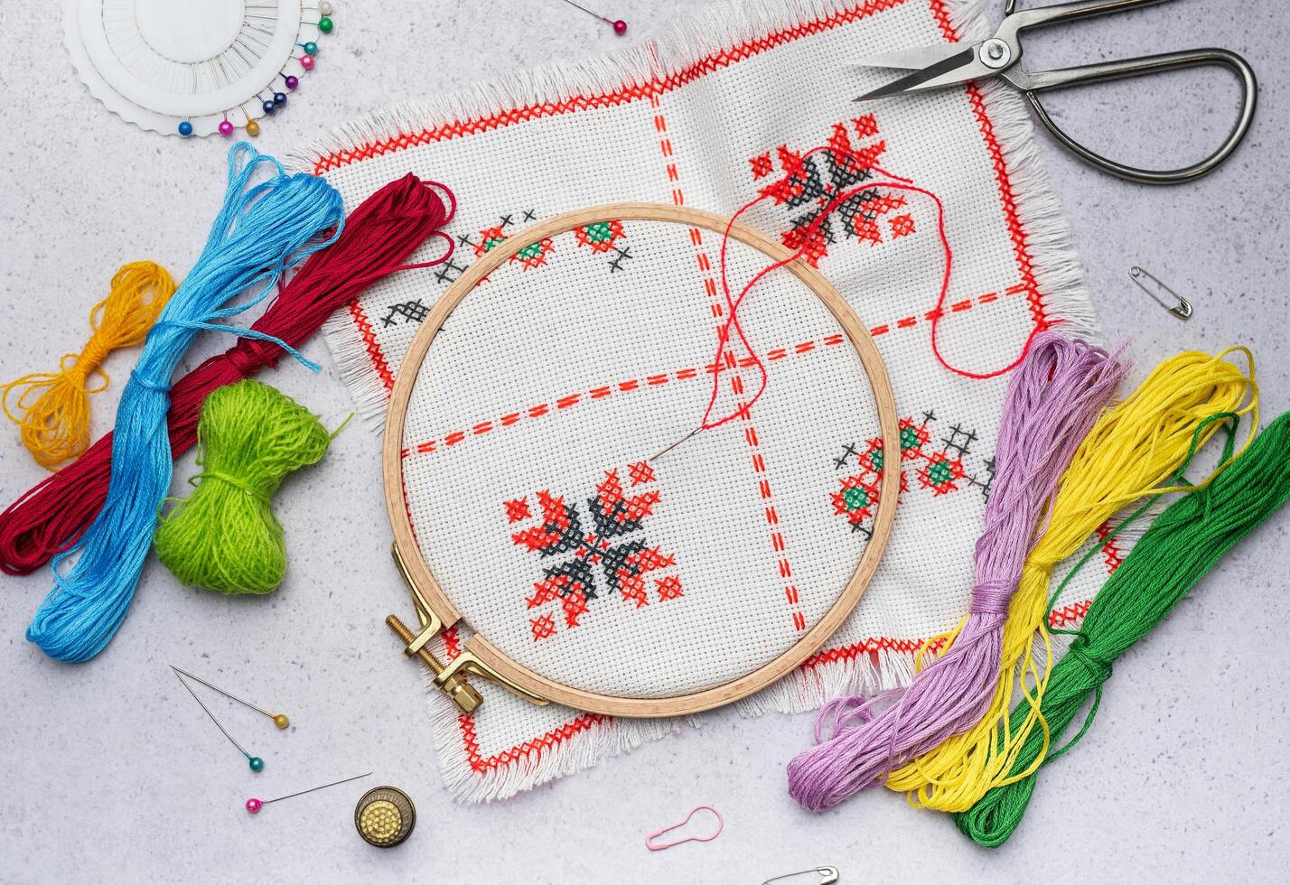 Embroidery with colored threads and various sewing accessories photo