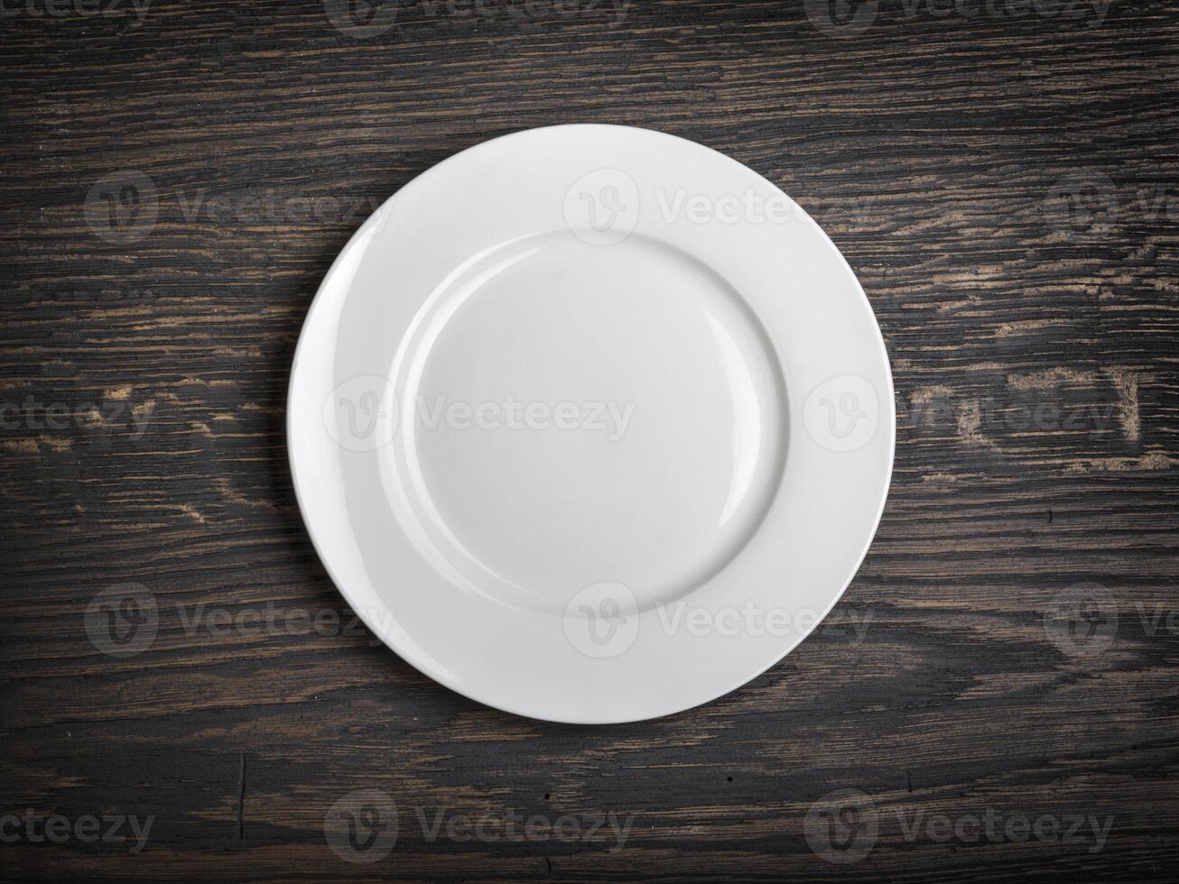 Empty white plate on wooden photo