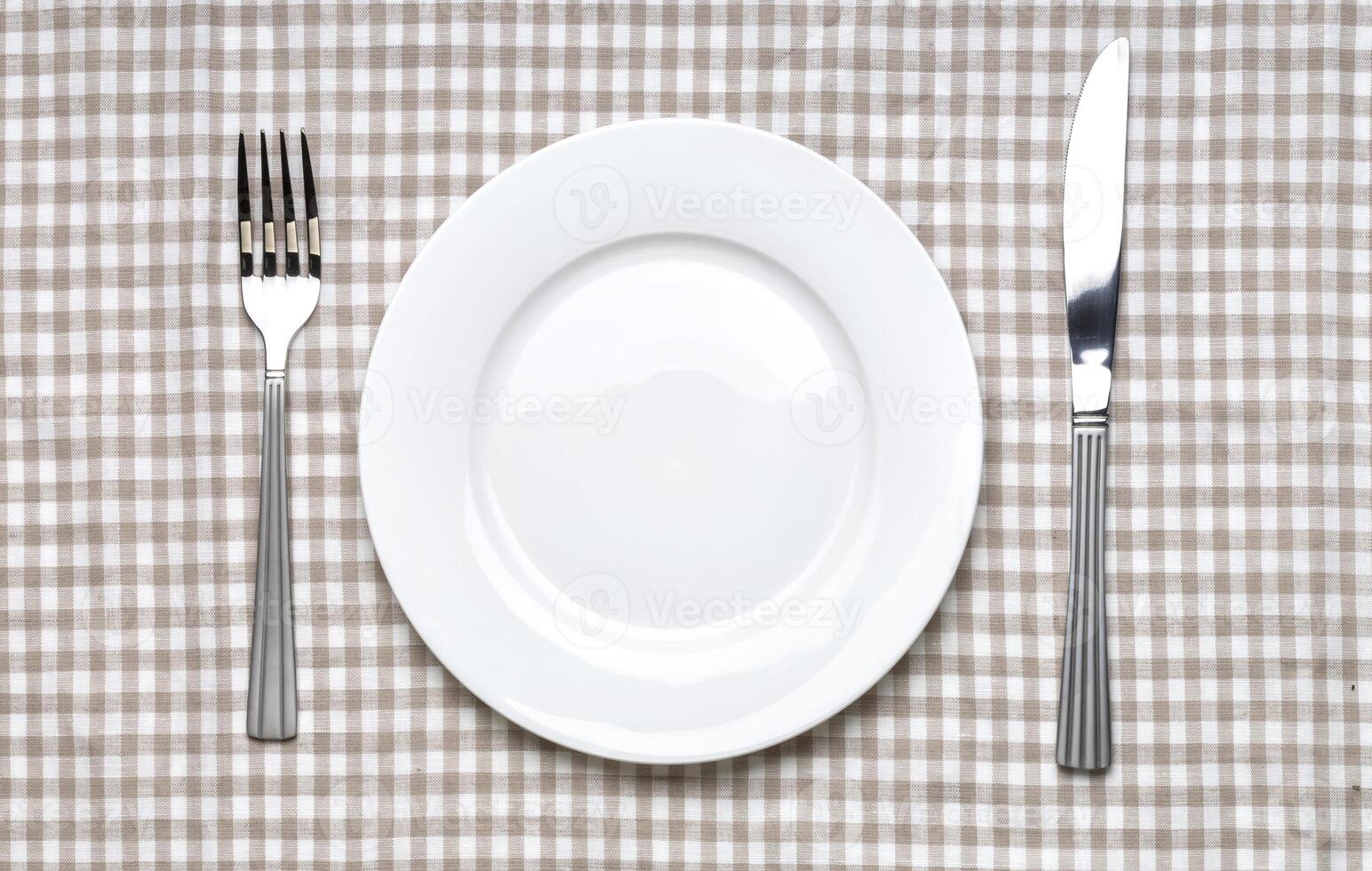 Empty white plate with fork and knife photo