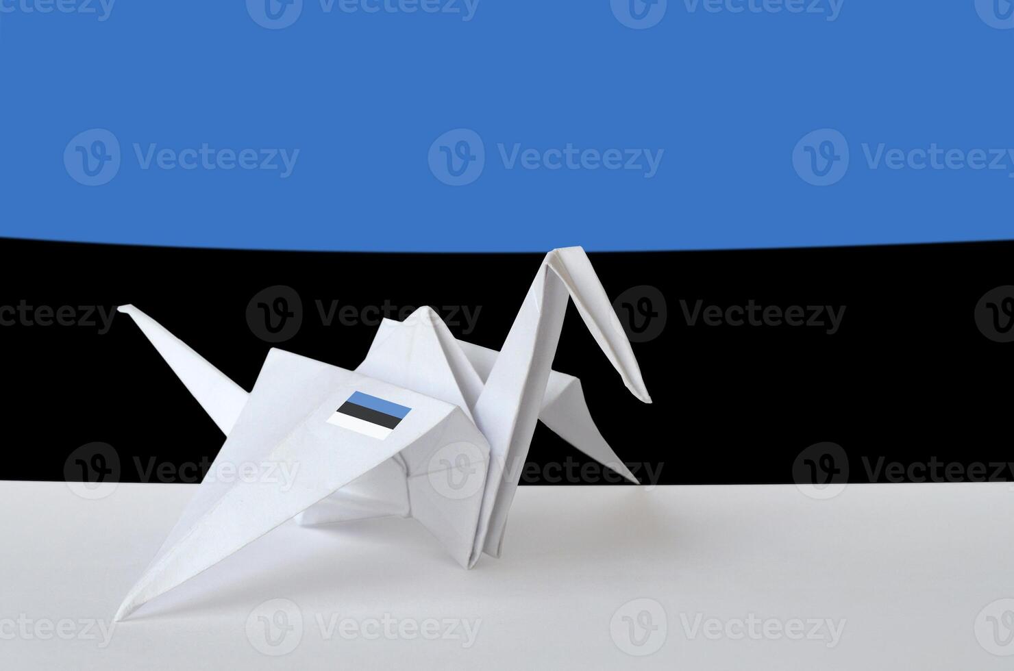 Estonia flag depicted on paper origami crane wing. Handmade arts concept photo