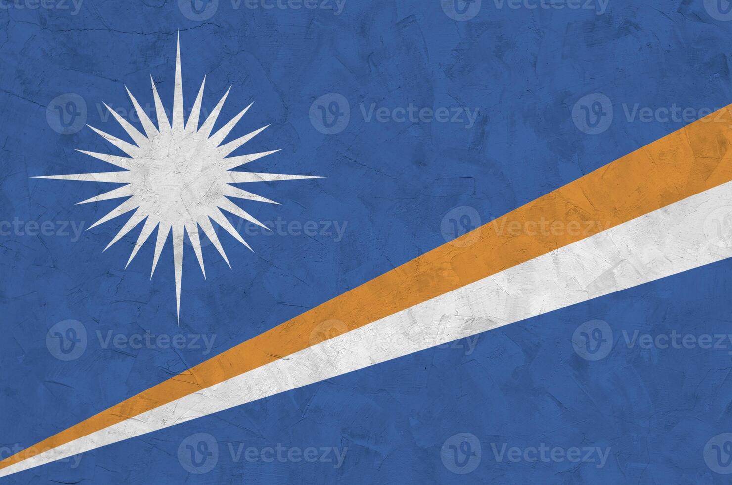 Marshall Islands flag depicted in bright paint colors on old relief plastering wall. Textured banner on rough background photo