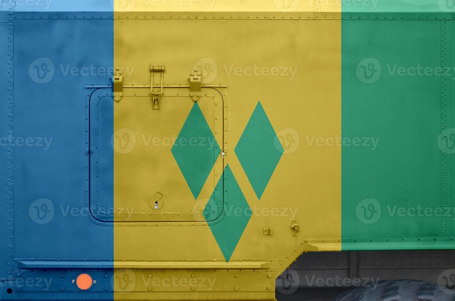 Saint Vincent and the Grenadines flag depicted on side part of military armored truck closeup. Army forces conceptual background photo