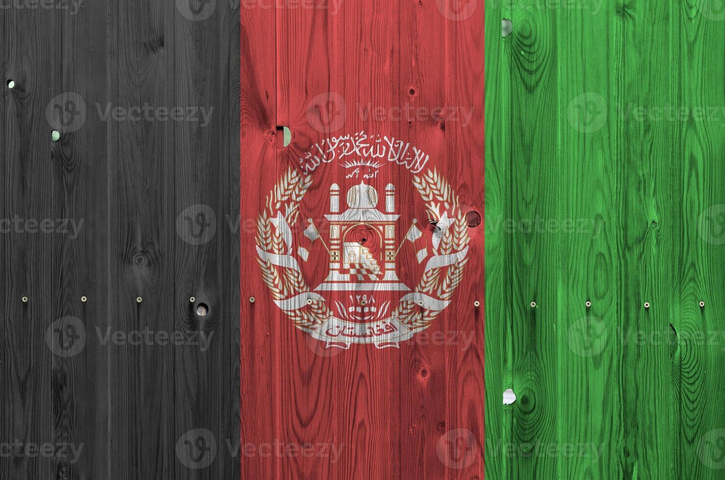 Afghanistan flag depicted in bright paint colors on old wooden wall. Textured banner on rough background photo