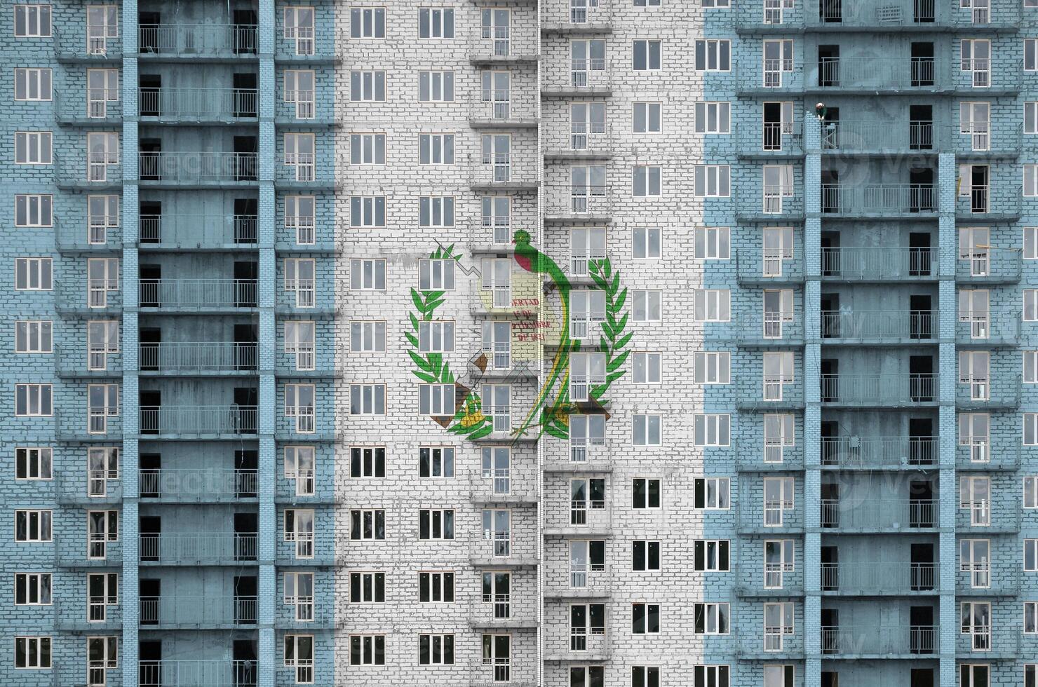 Guatemala bandera representado en pintar colores en de muchos pisos residencial edificio debajo construcción. texturizado bandera en ladrillo pared antecedentes foto