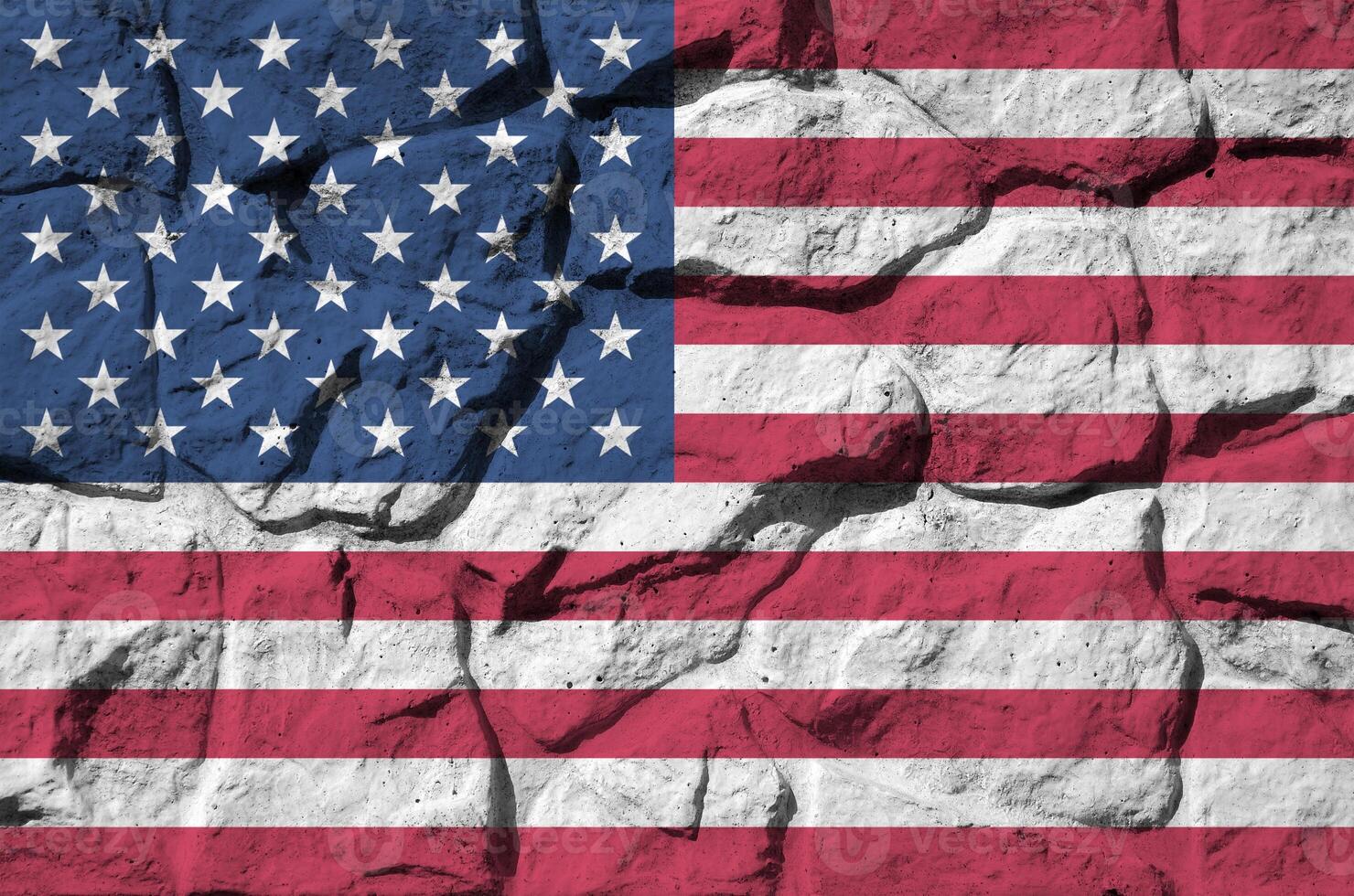 United States of America flag depicted in paint colors on old stone wall closeup. Textured banner on rock wall background photo