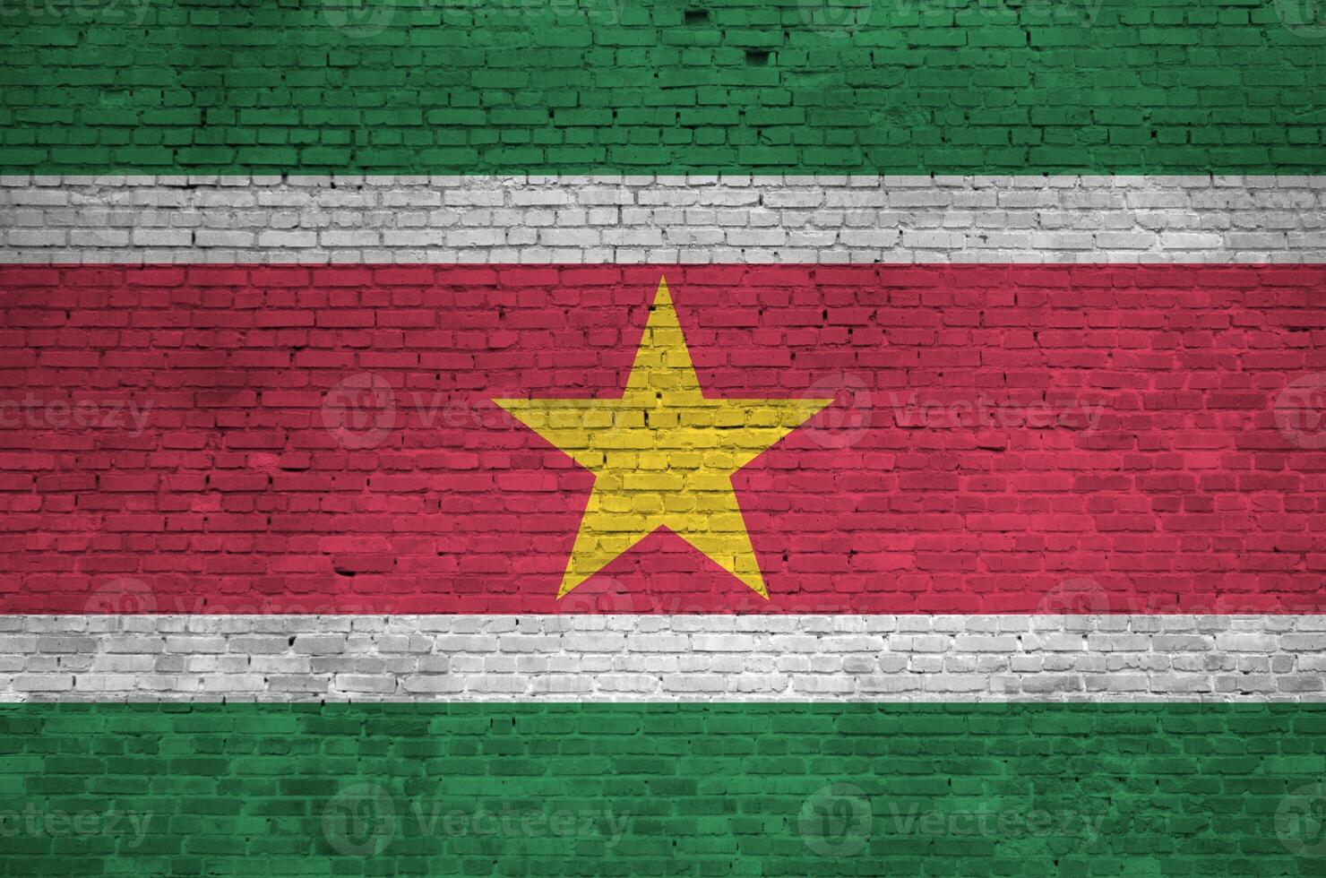 Suriname flag depicted in paint colors on old brick wall. Textured banner on big brick wall masonry background photo