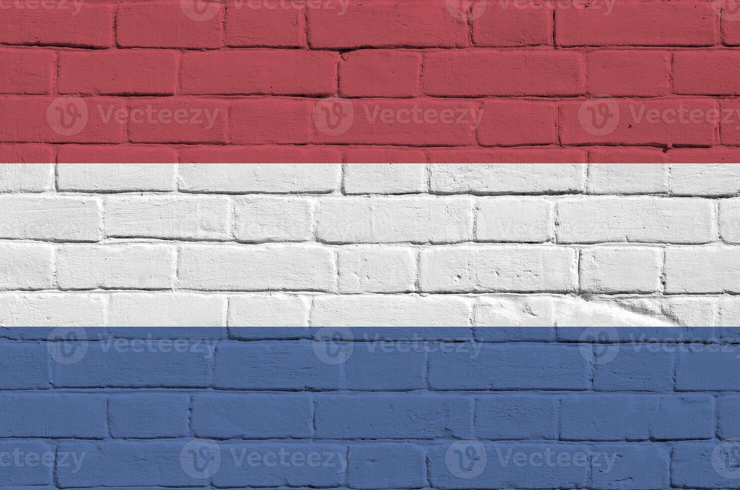 Netherlands flag depicted in paint colors on old brick wall. Textured banner on big brick wall masonry background photo