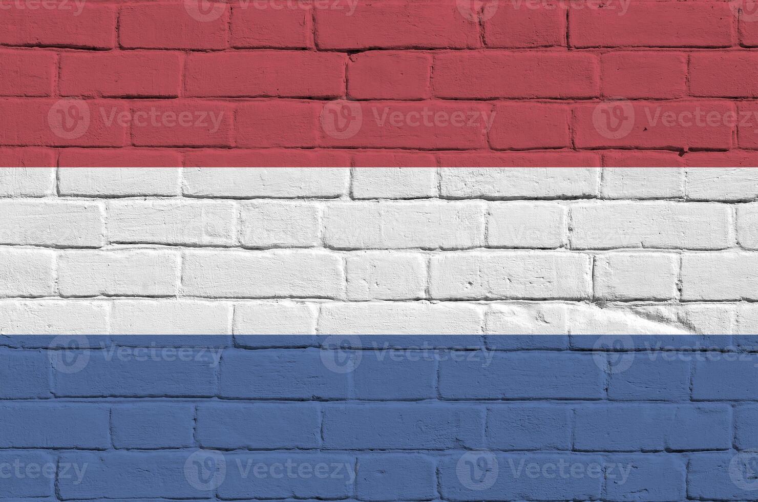 Netherlands flag depicted in paint colors on old brick wall. Textured banner on big brick wall masonry background photo