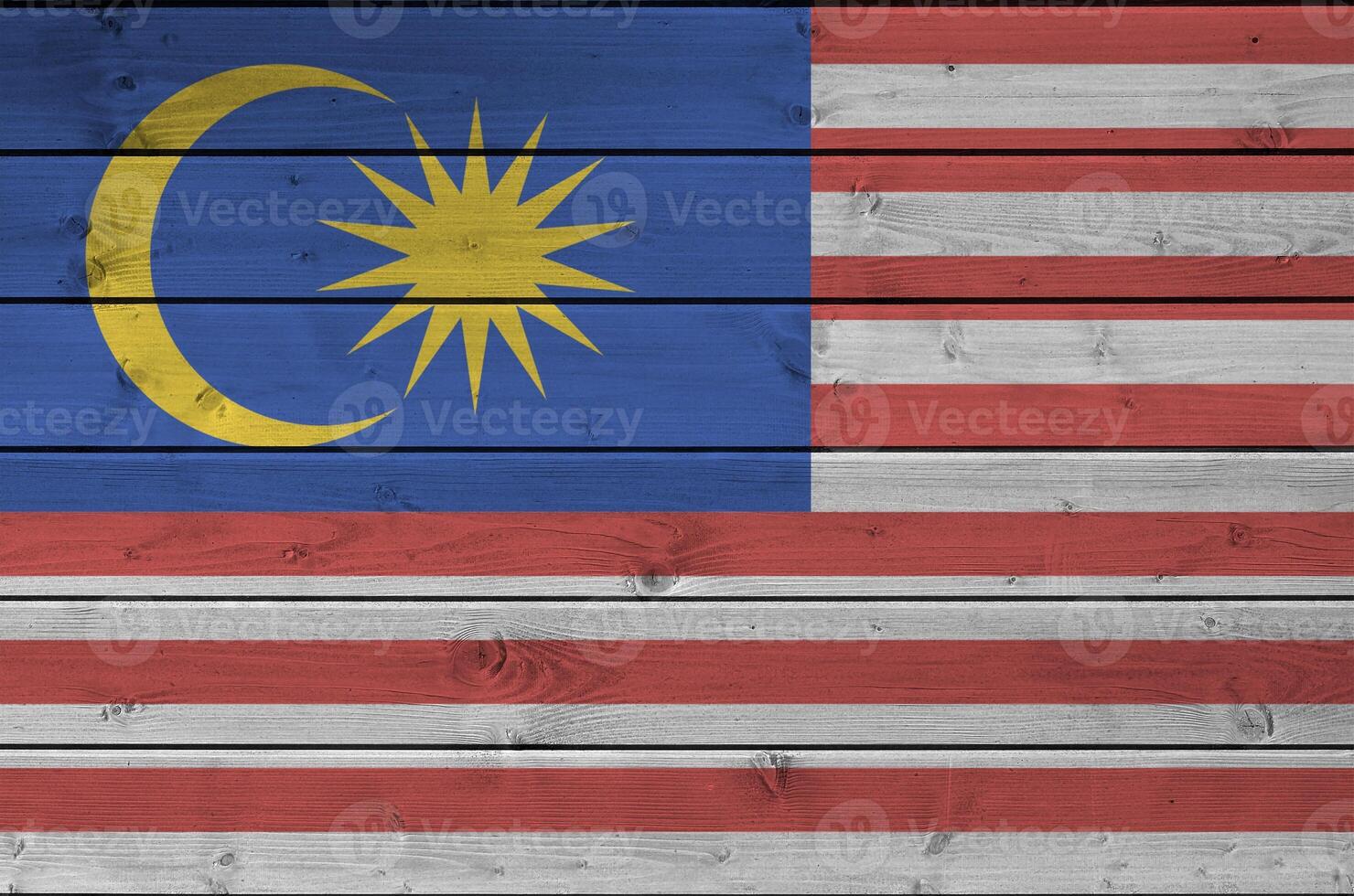 Malaysia flag depicted in bright paint colors on old wooden wall. Textured banner on rough background photo