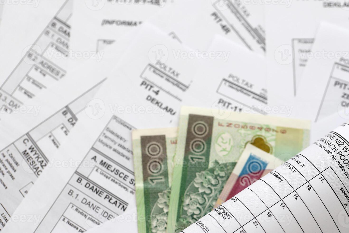Polish zloty money PLN on big amount of polish PIT, CIT and VAT tax forms close up. Accounting, bureaucracy and taxpayers routine photo
