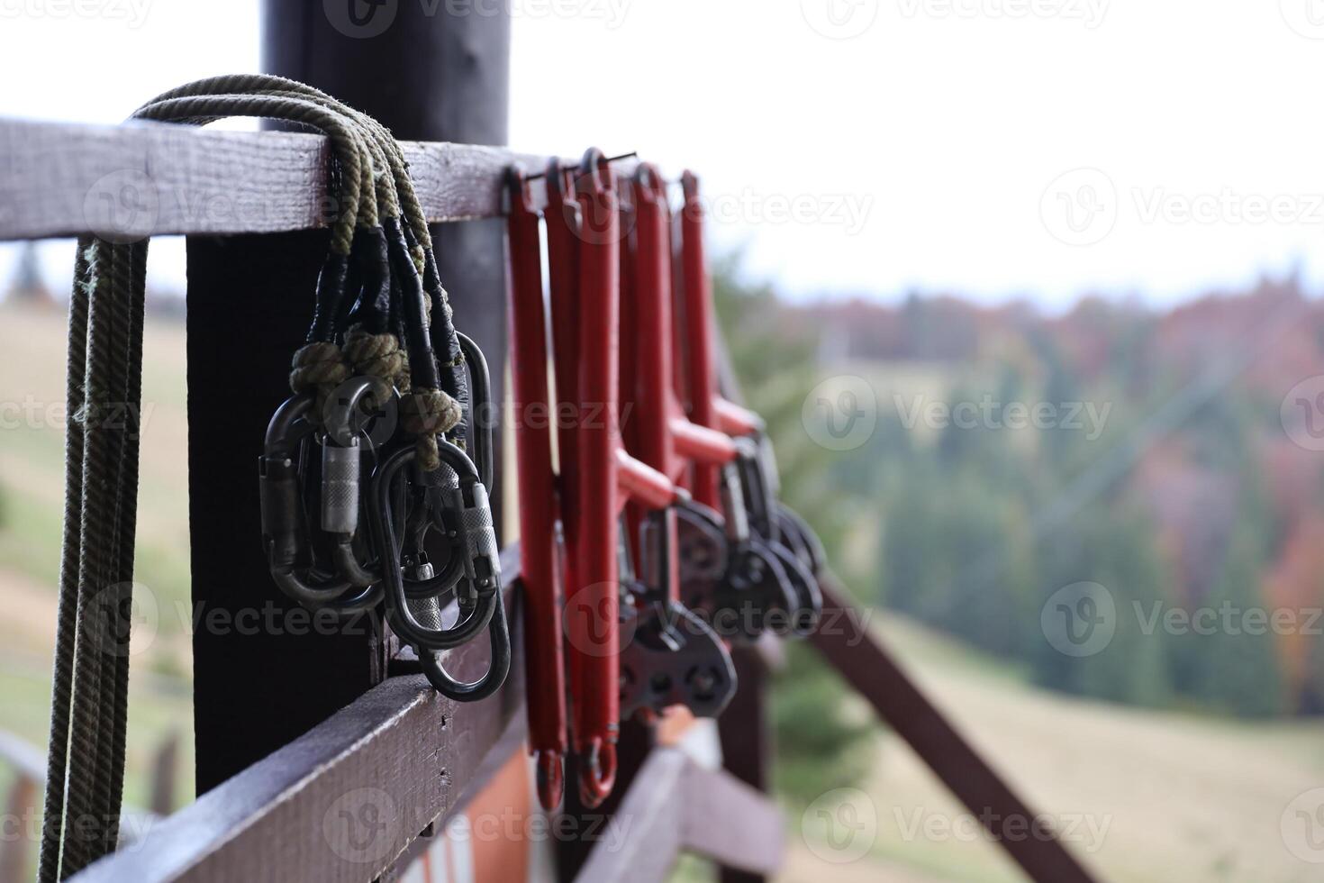 large metal locking carabiners with rope, climbing gear hanging on the store room. Height safety harness and arborist equipment photo