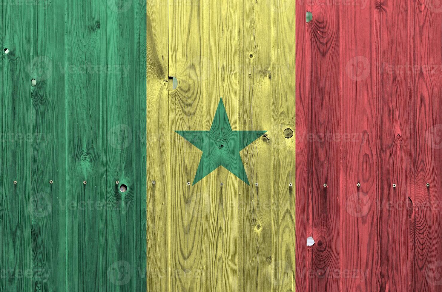 Senegal flag depicted in bright paint colors on old wooden wall. Textured banner on rough background photo