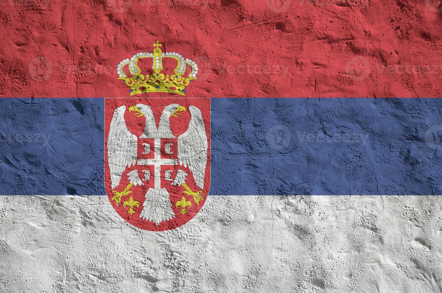 Serbia flag depicted in bright paint colors on old relief plastering wall. Textured banner on rough background photo