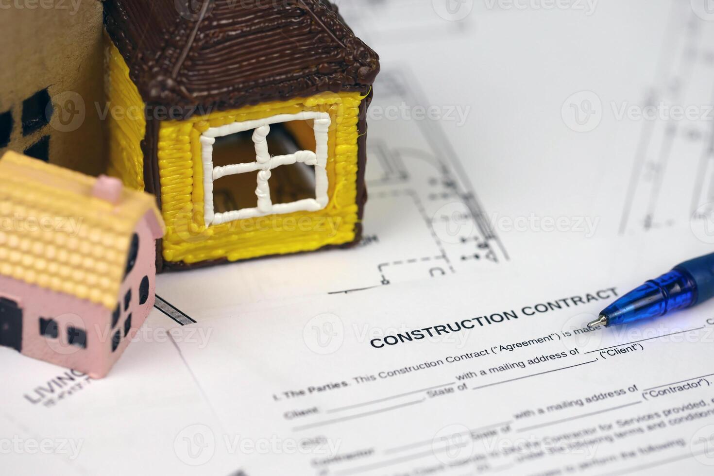 Residential construction agreement ready to sign with small toy houses and pen. Construction contract photo