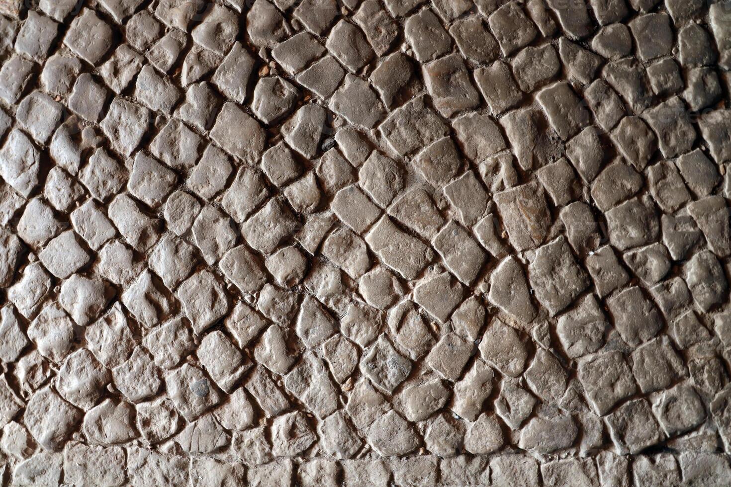 Paving stone pavement background texture. Cobblestone pave top view of old stony sidewalk photo