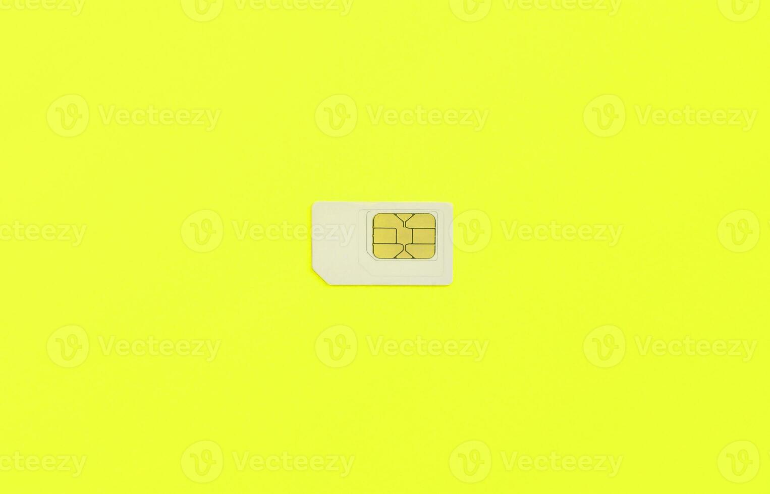 Subscriber identity module. White SIM card on yellow background photo