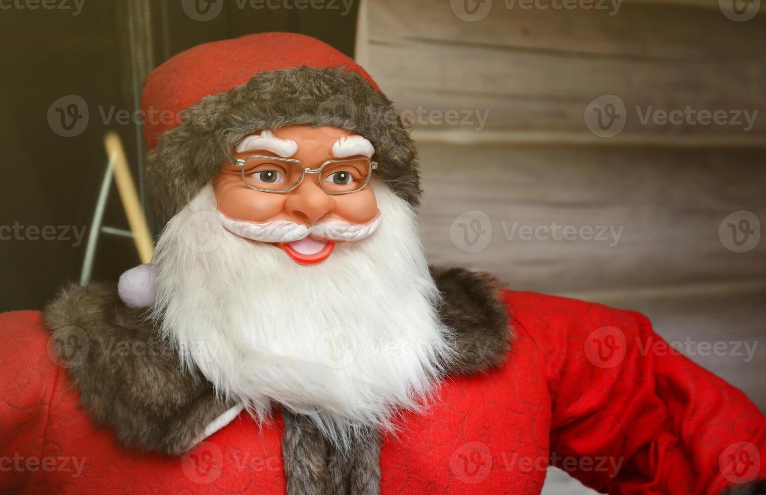 Santa claus big plastic figure with classic santa clothes close to wooden house photo