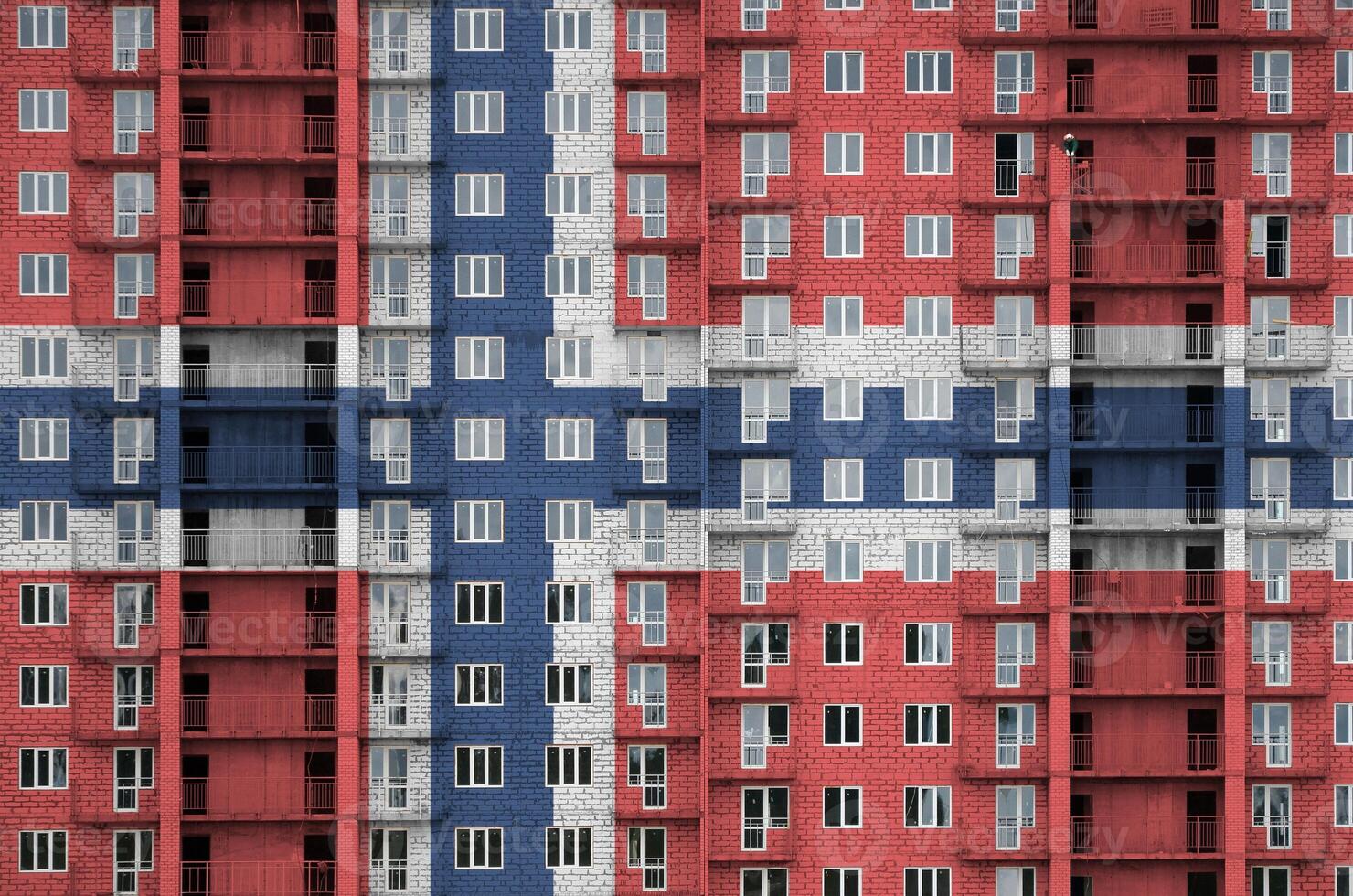 Norway flag depicted in paint colors on multi-storey residental building under construction. Textured banner on brick wall background photo