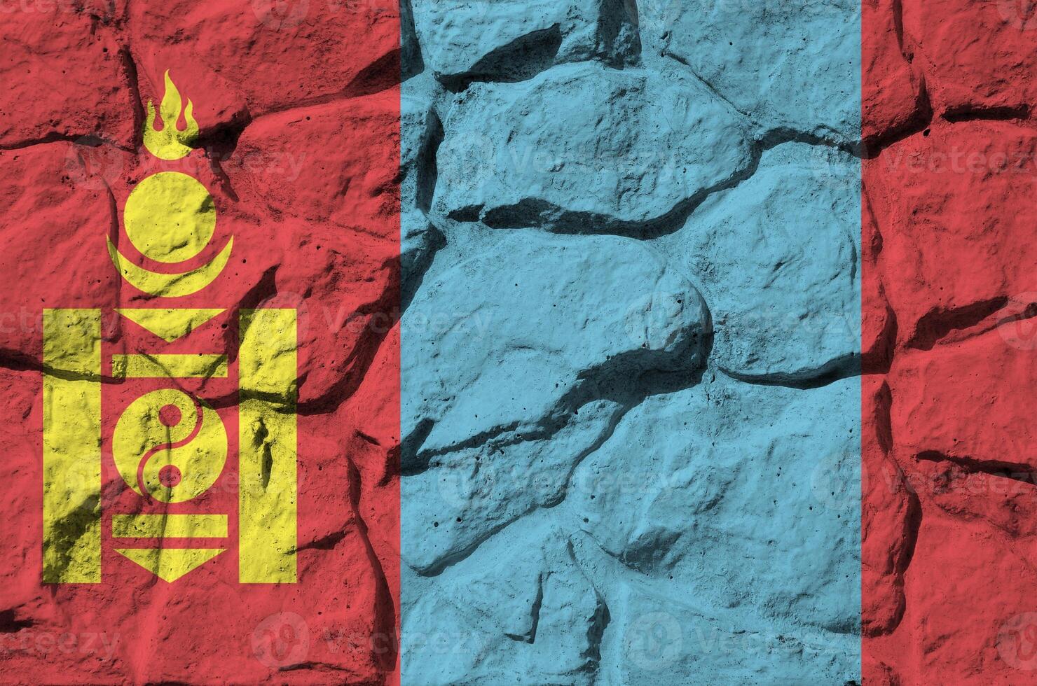 Mongolia flag depicted in paint colors on old stone wall closeup. Textured banner on rock wall background photo