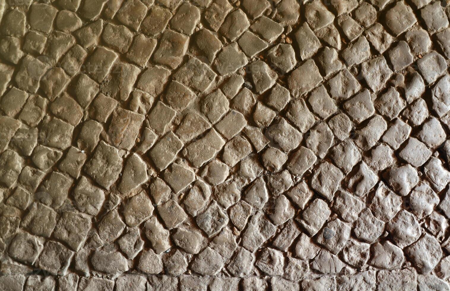 Paving stone pavement background texture. Cobblestone pave top view of old stony sidewalk photo