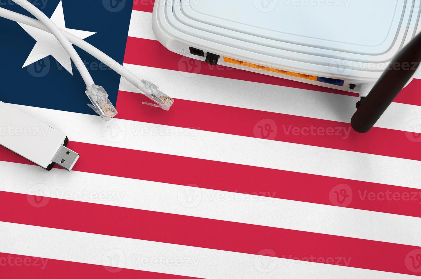 Liberia flag depicted on table with internet rj45 cable, wireless usb wifi adapter and router. Internet connection concept photo