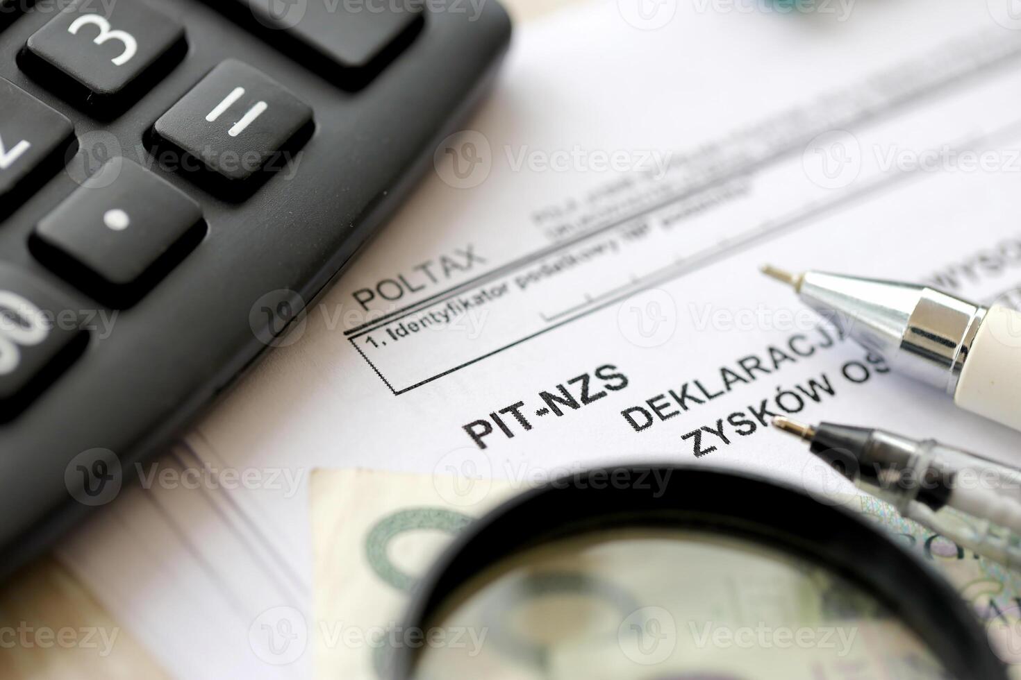 Declaration of income amount from unrealized profits obtained by enterprise as inheritance, PIT-NZS form on accountant table with pen and polish zloty money bills photo