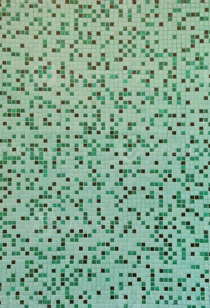 la textura de la pared, decorada con un mosaico de varios pequeños azulejos cuadrados. patrón abstracto de azulejos de cerámica en la pared foto