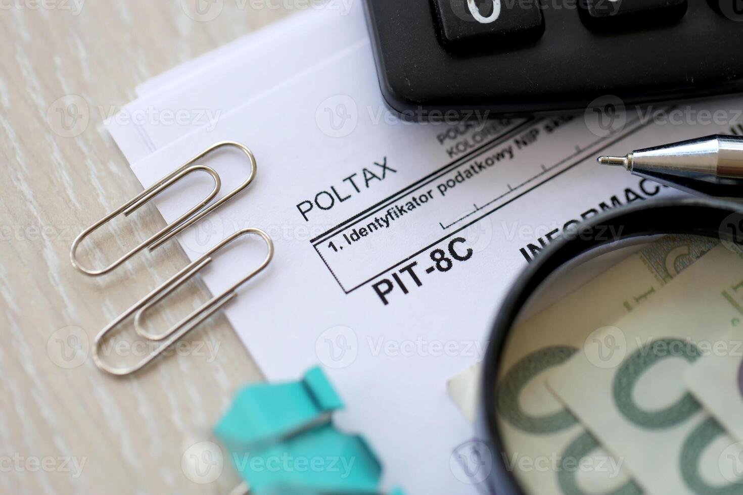 Information about some income from monetary capital, PIT-8C form on accountant table with pen and polish zloty money bills photo