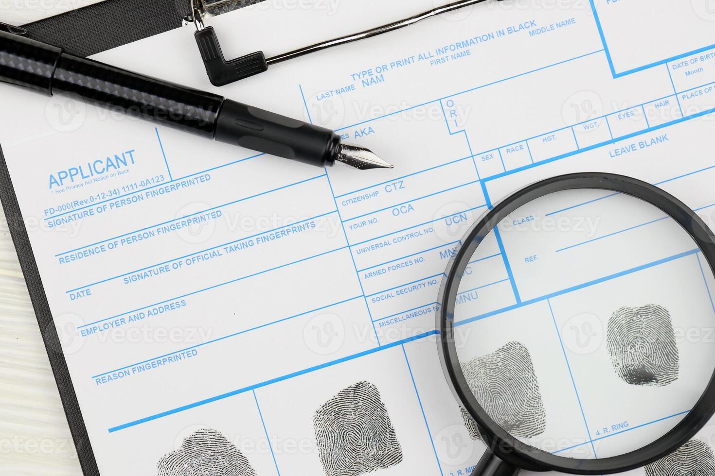 Fingerprints card police form on A4 tablet lies on office table with pen and magnifying glass photo