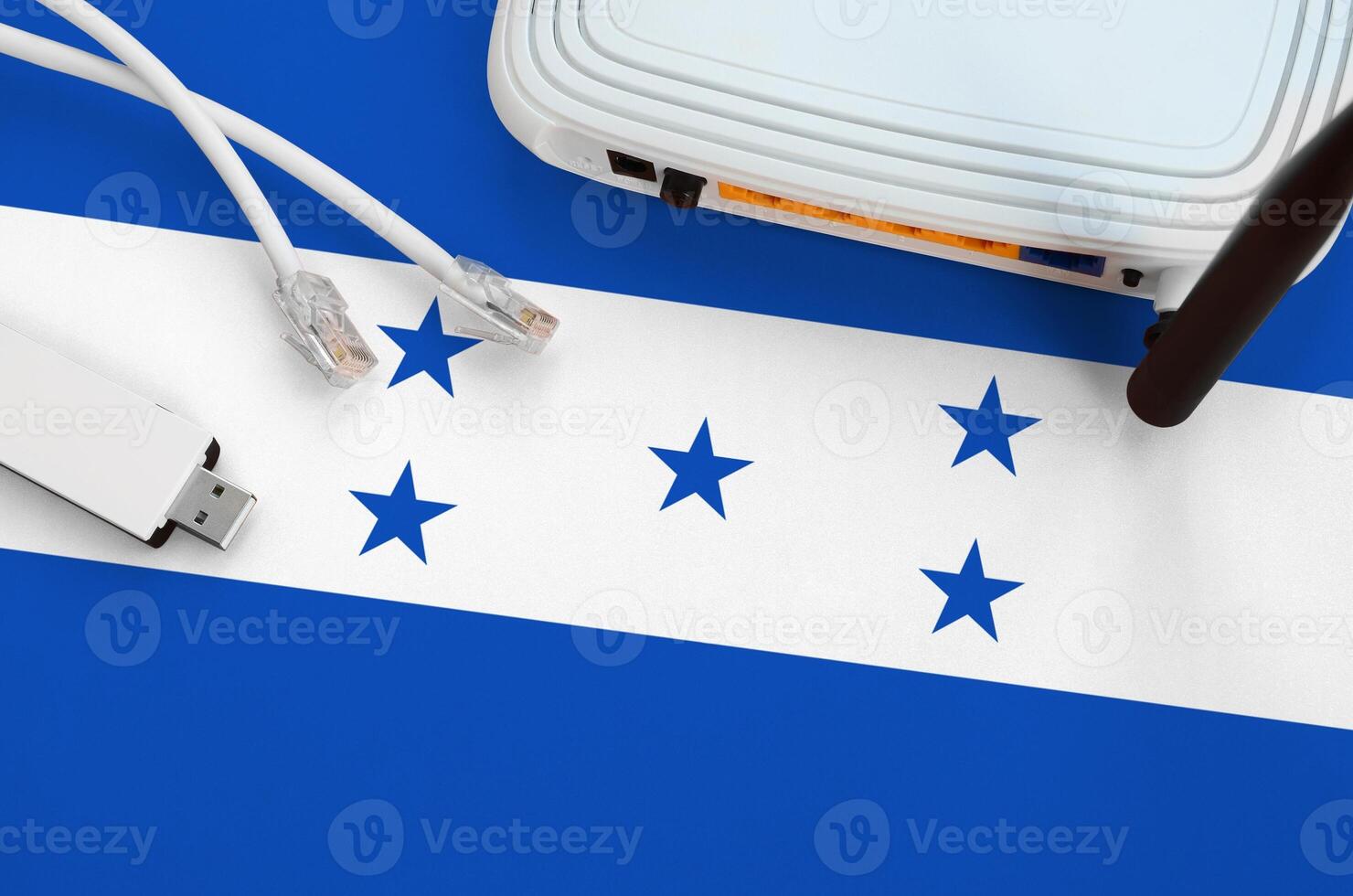 Honduras flag depicted on table with internet rj45 cable, wireless usb wifi adapter and router. Internet connection concept photo