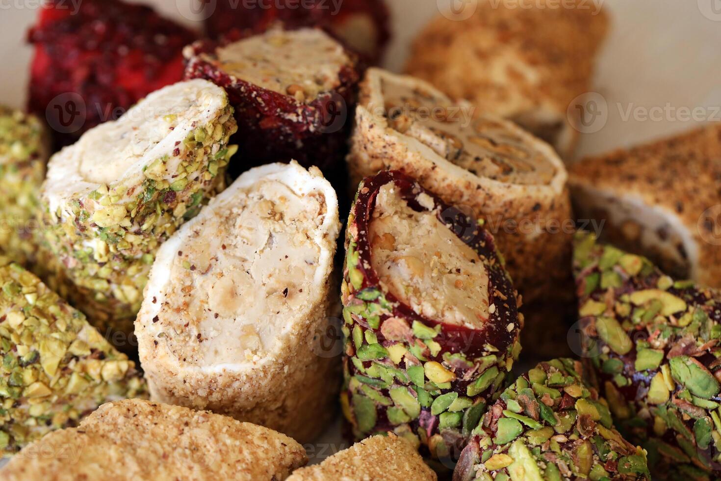 Many rolls of turkish delight with different flavors and fillings close up on table. Cutted Turk Lokumu photo