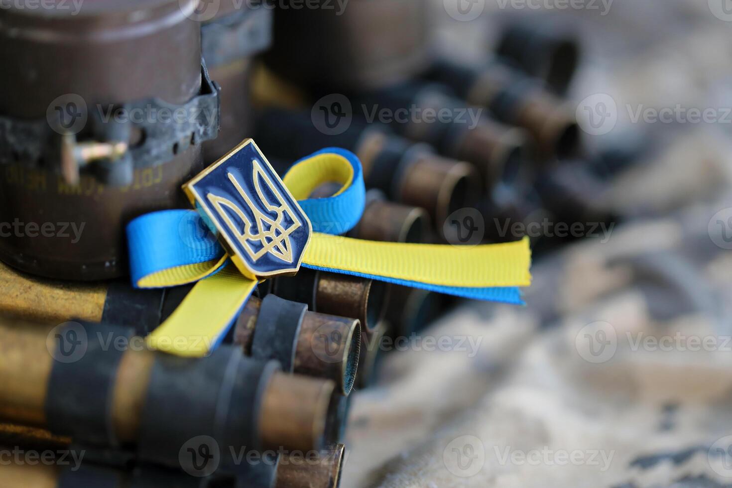 Ukrainian symbol on machine gun belt lies on ukrainian pixeled military camouflage photo