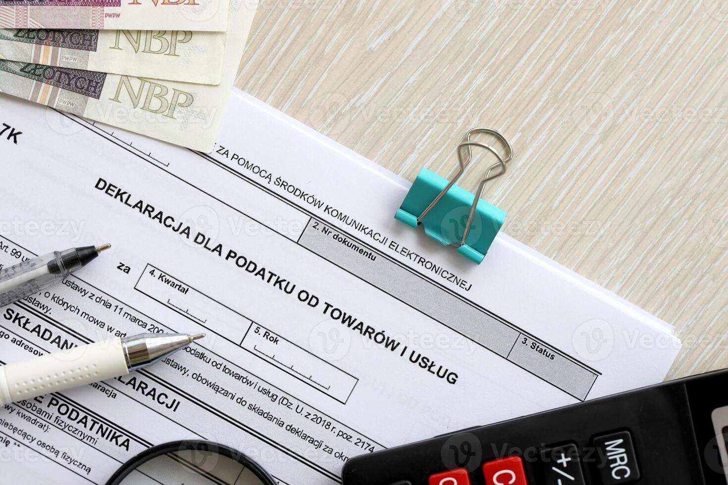 Declaration for tax on goods and services VAT-7K form on accountant table with pen and polish zloty money bills photo