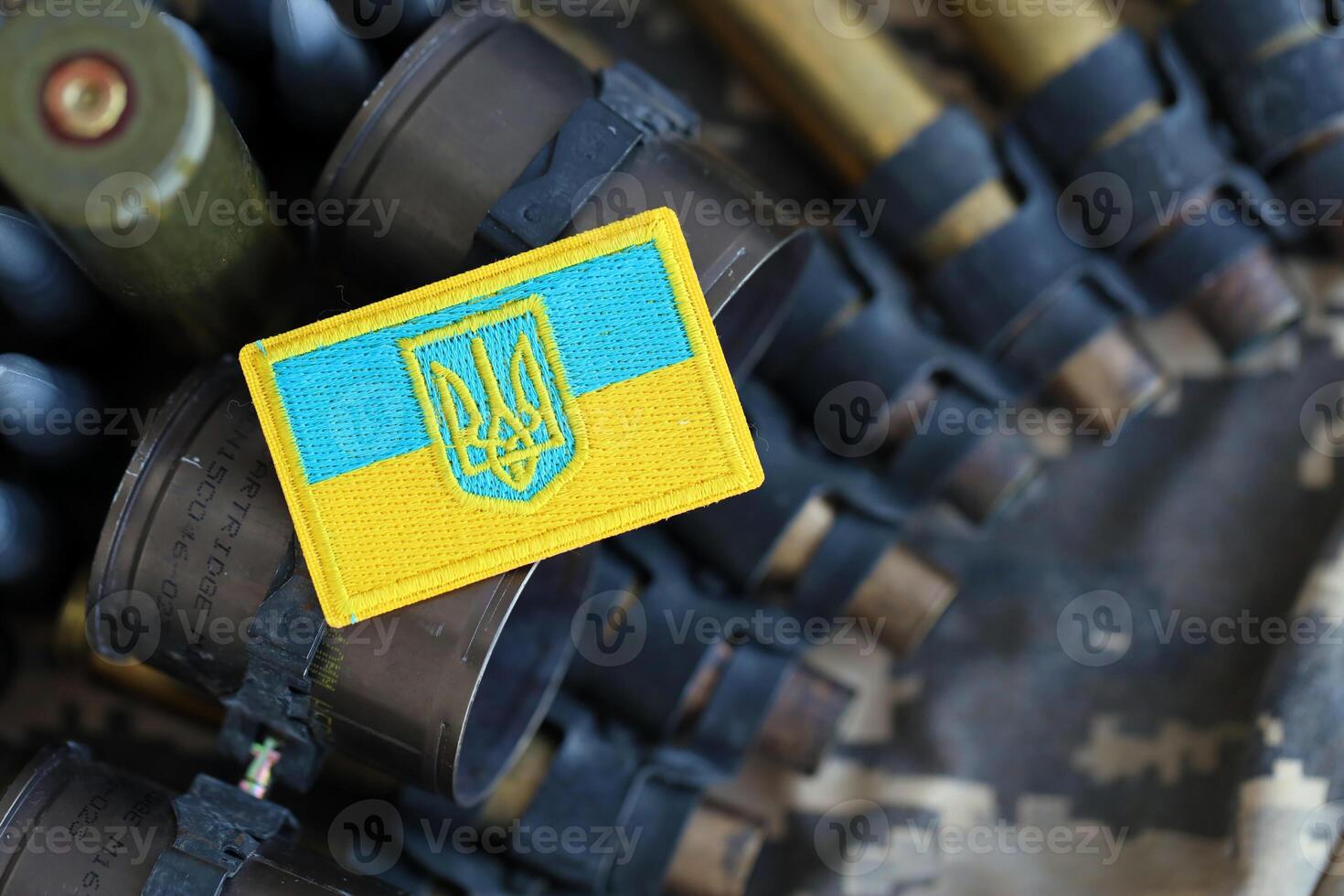 Ukrainian symbol on machine gun belt lies on ukrainian pixeled military camouflage photo