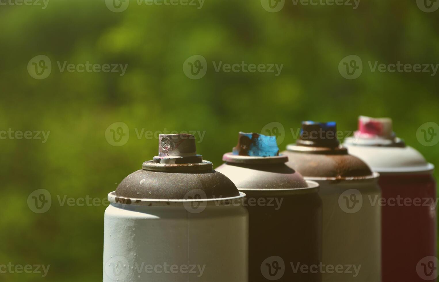 A few used aerosol paint sprayers lie on the windowsill in the workshop of a graffiti artist. The concept of street art and illegal drawing on the walls. Youth hobby photo
