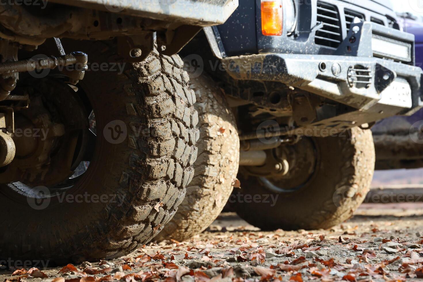 rueda de cerca en un campo paisaje con un barro la carretera. fuera del camino 4x4 suv automóvil con ditrito cuerpo después conducir en lodoso la carretera foto