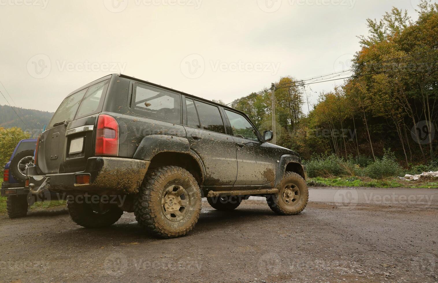 automóvil en un campo paisaje con un barro la carretera. fuera del camino 4x4 suv automóvil con ditrito cuerpo después conducir en lodoso la carretera foto