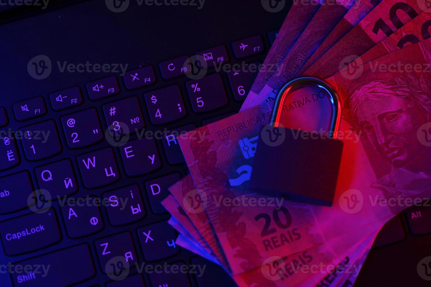 Closed padlock with brazilian reais money bills on laptop keyboard close up. Safe online banking or online shopping concept photo